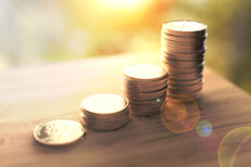Increasing returns in morning light Stacks of coins concept for investment income in morning light with lens flare effect