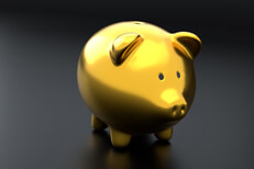 Shiny gold piggy bank Shiny gold metallic piggy bank on dark studio background and soft lighting