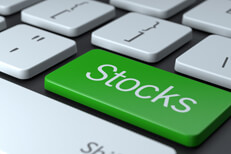 Laptop keyboard with large green Stocks key concept for buying stocks online