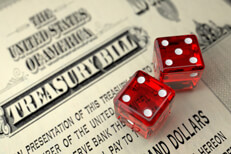 Old U.S. Treasury Bill with two dice concept for risk of investing in government treasuries