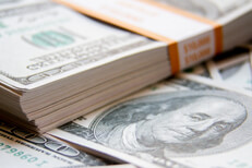 $10,000 cash bundle with scattered bills Stack of $10,000 banded bills with scattered 100 dollar bills