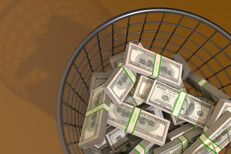 Trash can filled with money concept for waste or throwing money away view from top