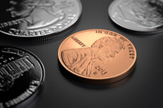 U.S. coins on dark background Penny, nickel, dime, and quarter on dark background