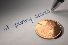 A penny saved U.S. penny on paper with pen writing A penny saved