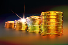 Stacks of gold coins increasing size representing investment gains over time