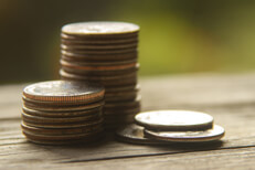 Stacks of coins on wood Coins stacked on wood planks with nature bokeh background