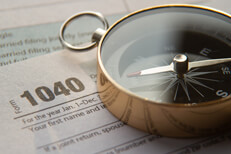 Concept image of 1040 tax form and navigation compass illustrating tax help or advice