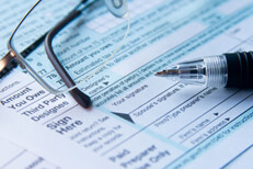 IRS tax form signature line IRS form 1040 signature line close up with reading glasses and ballpoint pen
