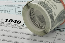 IRS form 1040 with roll of cash angled with rubber band