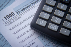 Top view photo of calculator on top of IRS 1040 tax forms