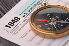 IRS form 1040 on wood background with navigation compass concept for tax help, direction, or advice