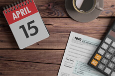 Daily calendar showing April 15 with coffee, calculator, and IRS form 1040